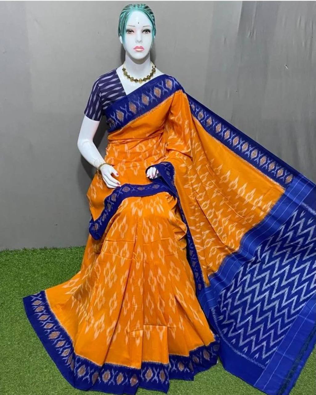 Orange and blue traditional Hooriya Fashion saree with intricate patterns draped on mannequin